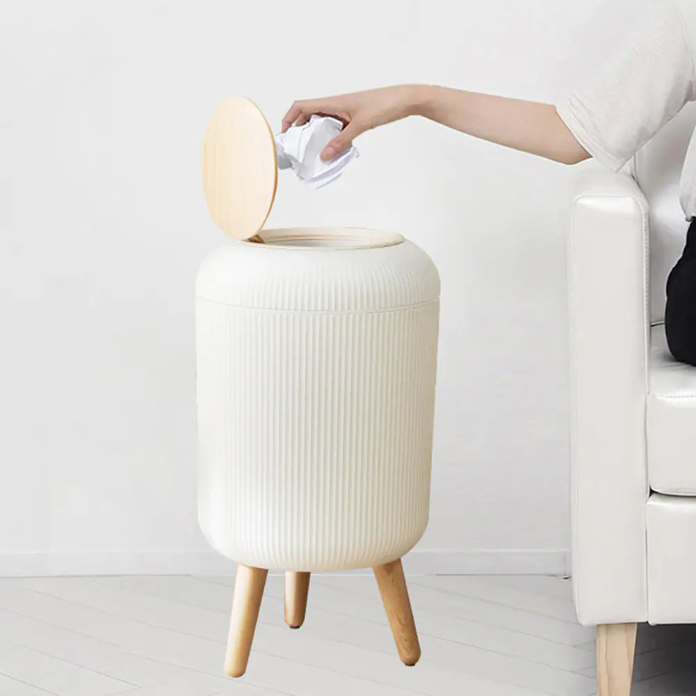 Sensor-Activated Kitchen Bin with lid open, hand dropping in paper, in a real living room