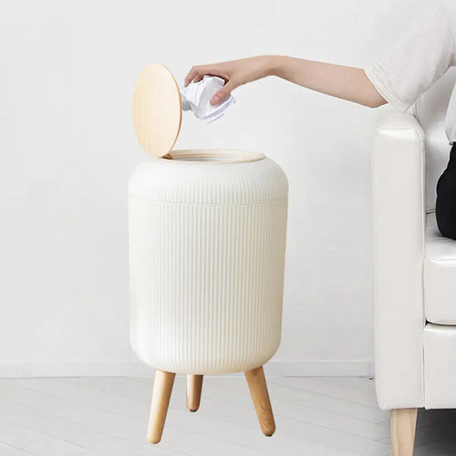 Sensor-Activated Kitchen Bin with lid open, hand dropping in paper, in a real living room