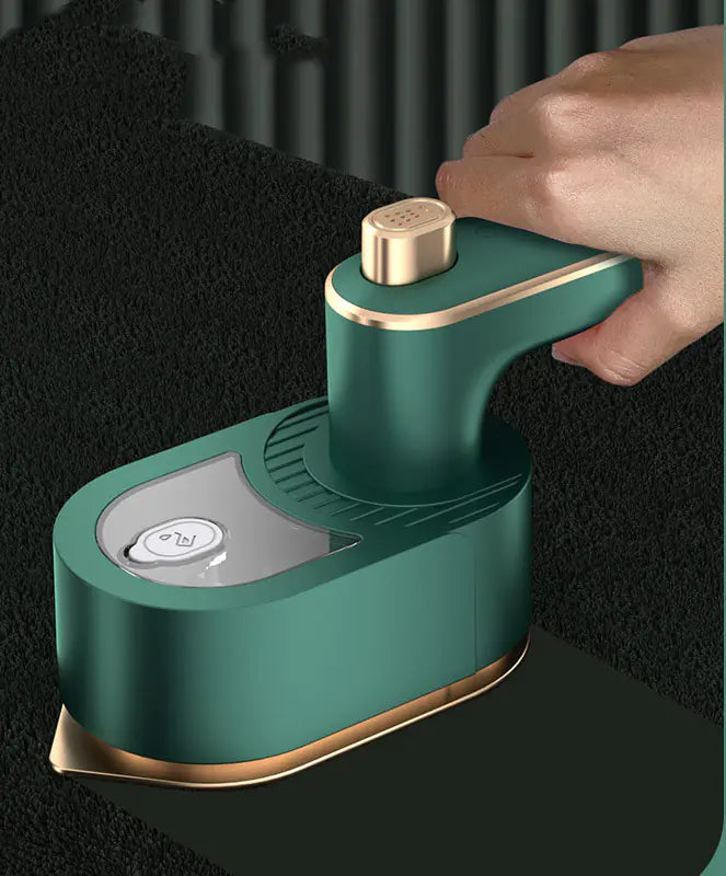 Travel Garment Steamer in Green, in use smoothing fabric