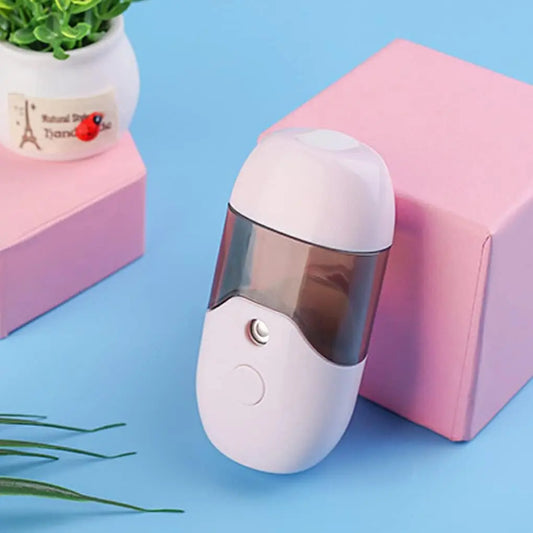 Levitating Mist Humidifier in Pink, styled on a desk with a plant
