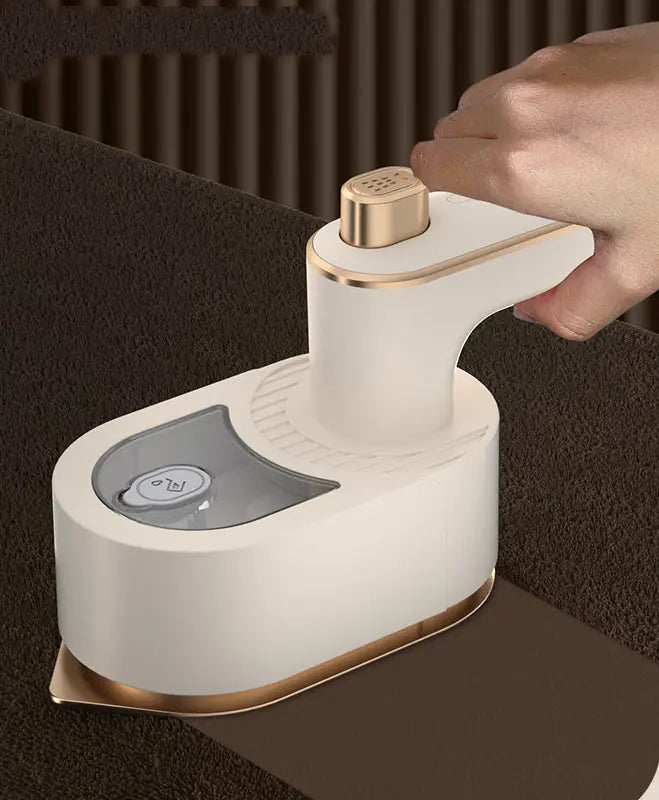 Travel Garment Steamer in Beige, in use smoothing fabric