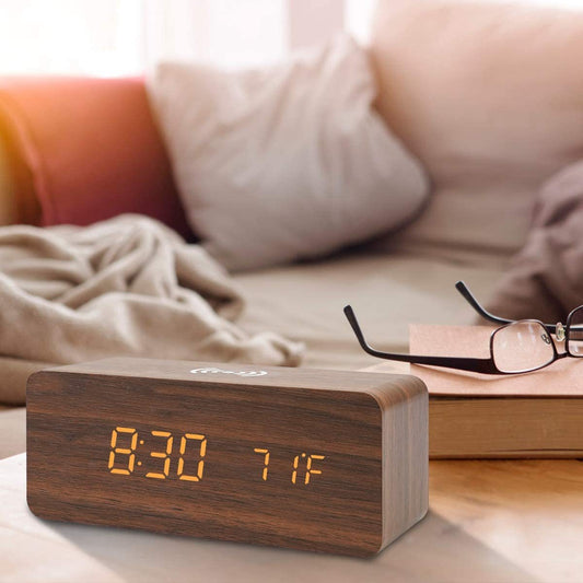 Timber Charge Wireless Alarm Clock on a nightstand with phone charging on top